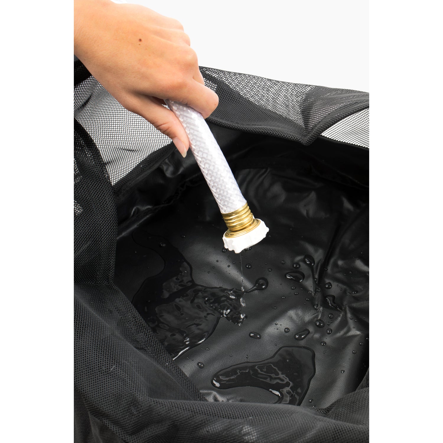 Hand placing a white hose into the interior of an RV hose bag, demonstrating the waterproof barrier feature. The image highlights the bag's ability to contain water, ensuring that hoses remain dry and clean. This essential RV accessory is perfect for organizing hoses in travel trailers and mobile homes, preventing contamination and maintaining cleanliness. The hose bag is a crucial camper accessory for RV camping, providing a durable and waterproof solution for hose storage.